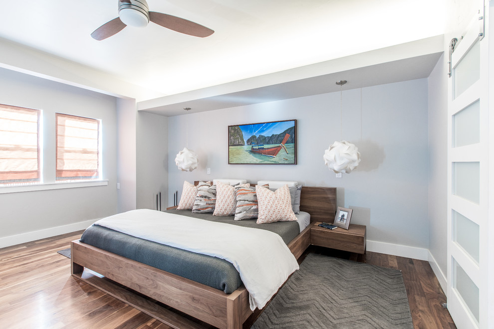 Photo of a large contemporary master bedroom in Denver with grey walls, dark hardwood floors, no fireplace and brown floor.