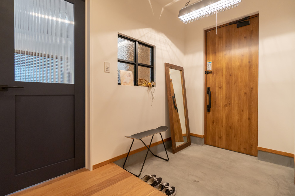 Foto på en industriell hall, med vita väggar, en enkeldörr och mellanmörk trädörr