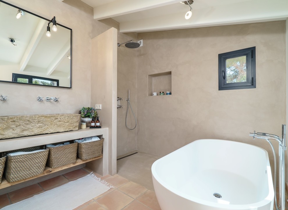 Inspiration for a mediterranean master bathroom in Alicante-Costa Blanca with open cabinets, a freestanding tub, a curbless shower, grey walls, an open shower, terra-cotta floors, a trough sink, beige floor and beige benchtops.