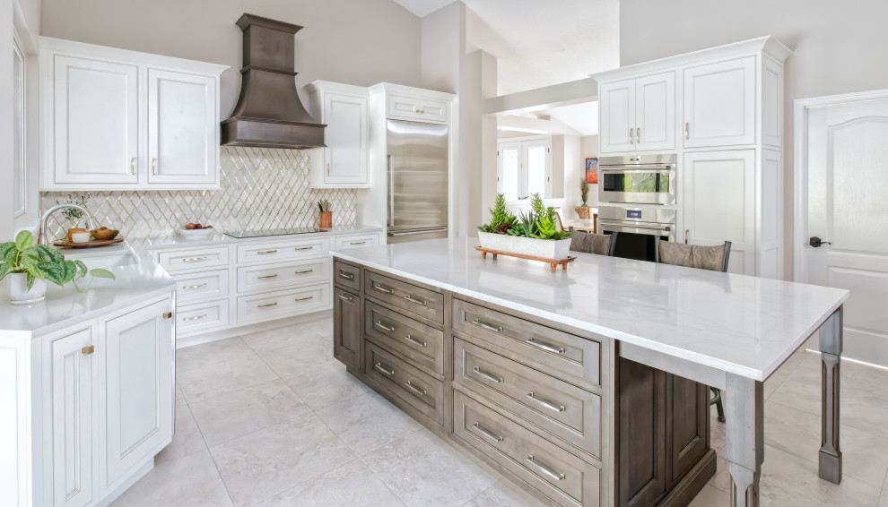 Large transitional u-shaped eat-in kitchen in Orlando with a single-bowl sink, beaded inset cabinets, white cabinets, quartz benchtops, white splashback, mosaic tile splashback, stainless steel appliances, porcelain floors, with island, white floor and white benchtop.