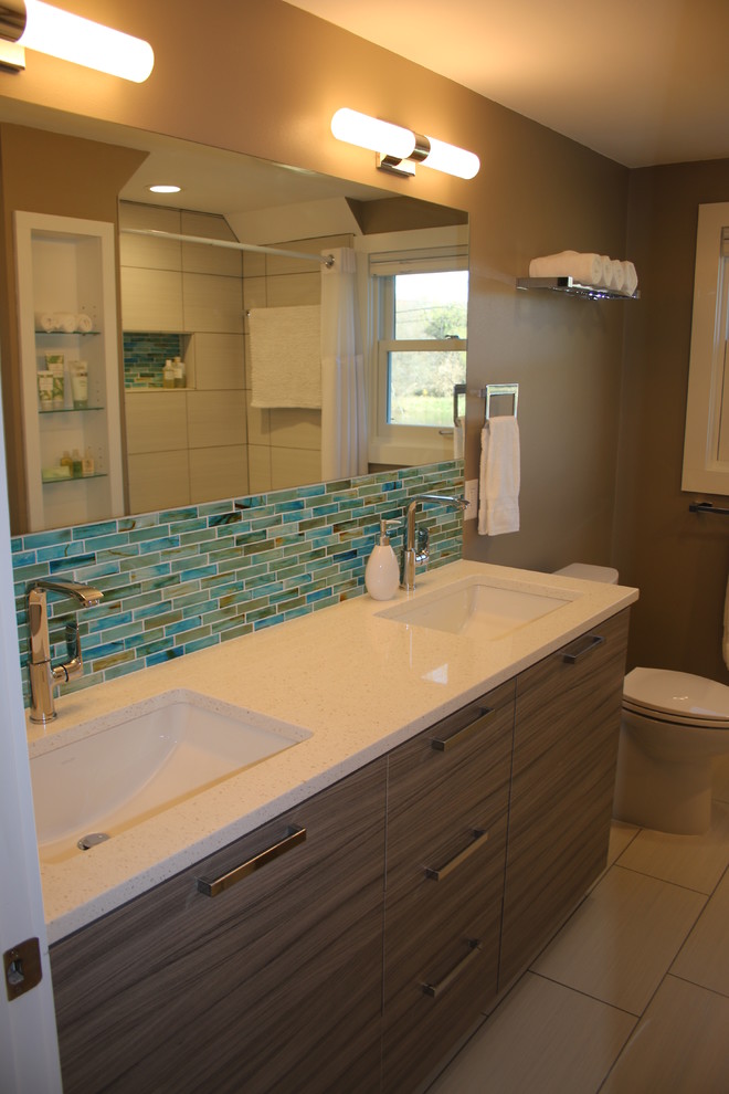 Mid-sized modern bathroom in Milwaukee with flat-panel cabinets, grey cabinets, an alcove tub, an alcove shower, multi-coloured tile, glass sheet wall, grey walls, porcelain floors, an undermount sink and engineered quartz benchtops.