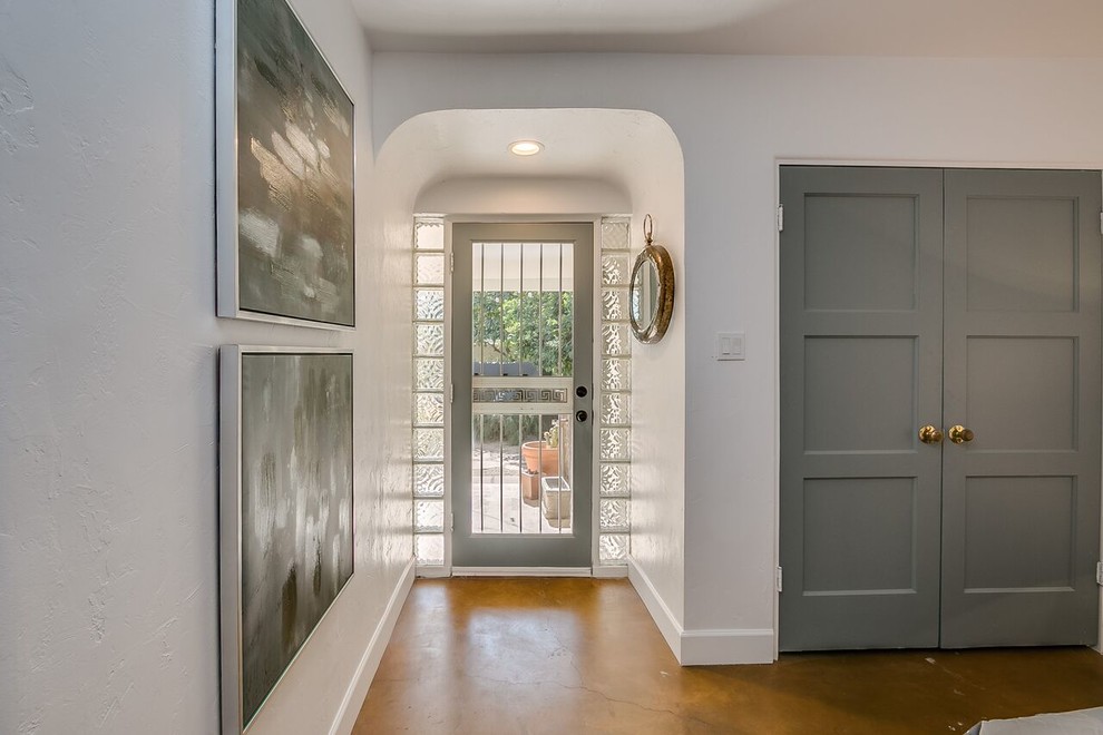Mid-sized transitional concrete floor and brown floor entry hall photo in Phoenix with white walls and a glass front door