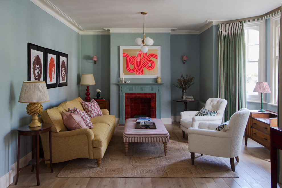 Inspiration for a large traditional formal enclosed living room in London with blue walls, light hardwood floors, a standard fireplace and a wood fireplace surround.