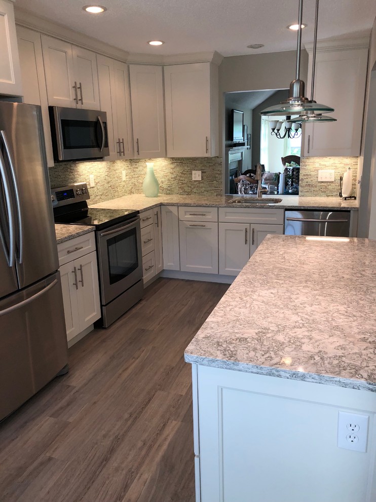 Inspiration for a mid-sized beach style l-shaped separate kitchen in New York with an undermount sink, shaker cabinets, white cabinets, quartzite benchtops, blue splashback, glass tile splashback, stainless steel appliances, laminate floors, no island, grey floor and green benchtop.
