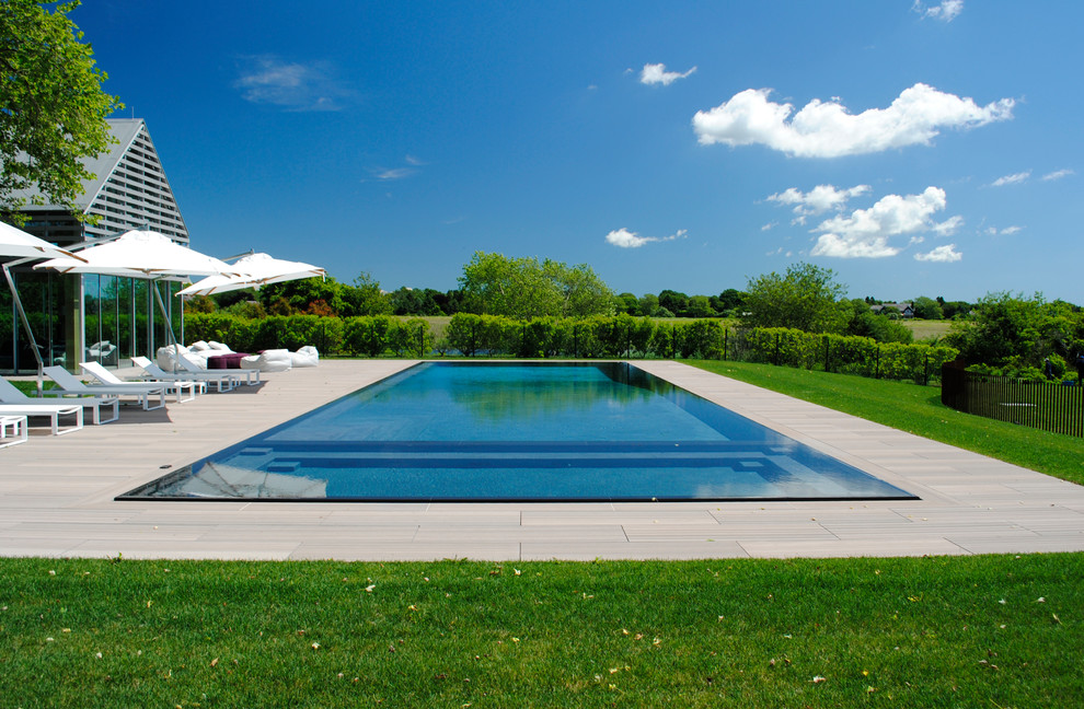 Hot tub - huge contemporary backyard concrete paver and rectangular infinity hot tub idea in New York