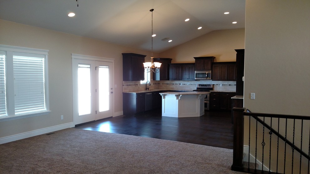 Open concept kitchen - large transitional u-shaped dark wood floor open concept kitchen idea with an undermount sink, shaker cabinets, dark wood cabinets, granite countertops, stone tile backsplash, stainless steel appliances and an island