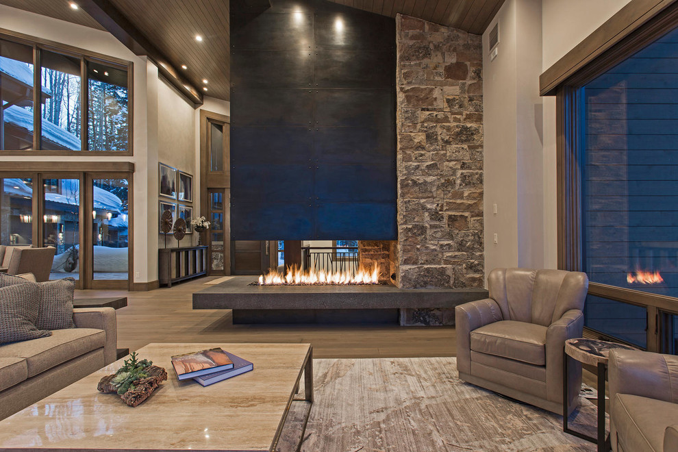 Photo of an expansive contemporary formal open concept living room in Salt Lake City with grey walls, medium hardwood floors, a two-sided fireplace, a metal fireplace surround and no tv.