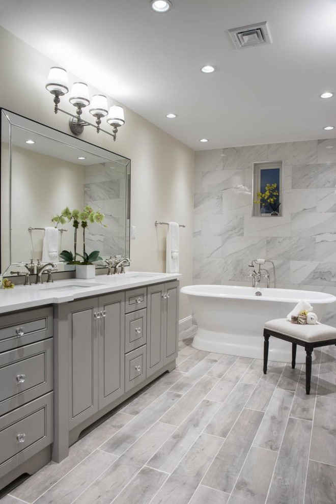 Design ideas for a bathroom in Miami with furniture-like cabinets, grey cabinets, a freestanding tub, marble and engineered quartz benchtops.