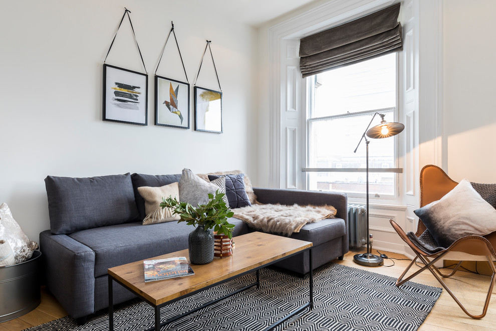 Scandinavian living room in London with white walls, light hardwood floors and beige floor.