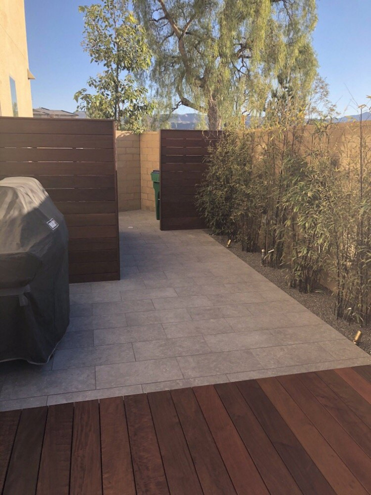 Design ideas for a contemporary backyard and ground level deck in Orange County with with privacy feature.