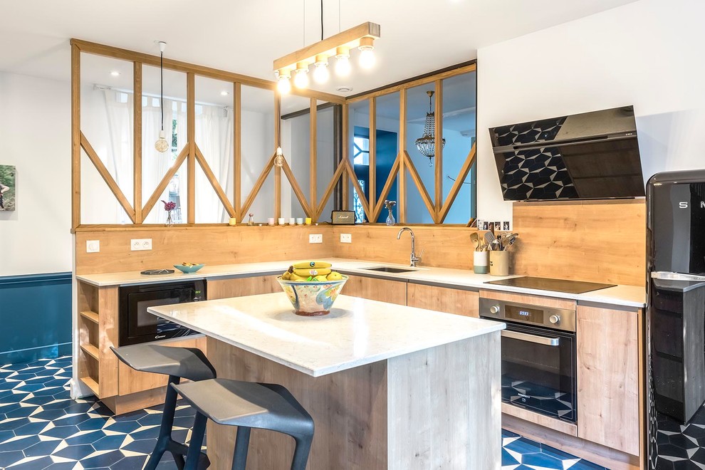 Inspiration for a contemporary l-shaped kitchen in Other with an undermount sink, flat-panel cabinets, light wood cabinets, beige splashback, timber splashback, black appliances, with island, blue floor and white benchtop.