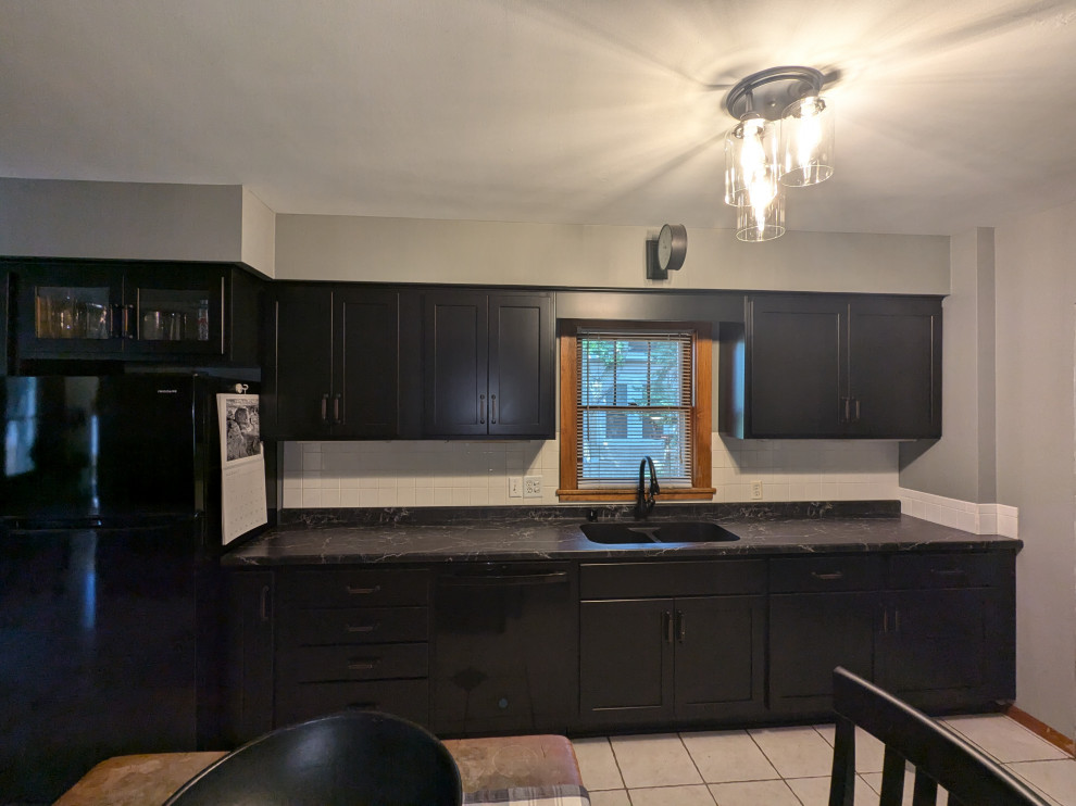 Example of a mid-sized transitional eat-in kitchen design with shaker cabinets, black cabinets, laminate countertops and black countertops