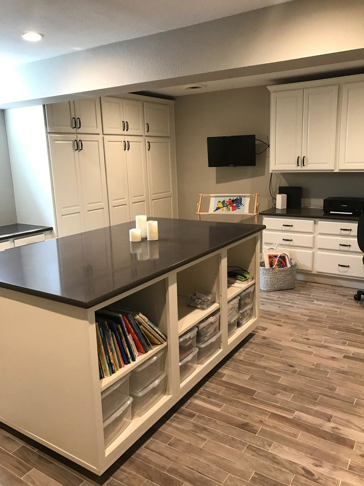Design ideas for a mid-sized transitional craft room in Denver with grey walls, porcelain floors, no fireplace, a built-in desk and brown floor.