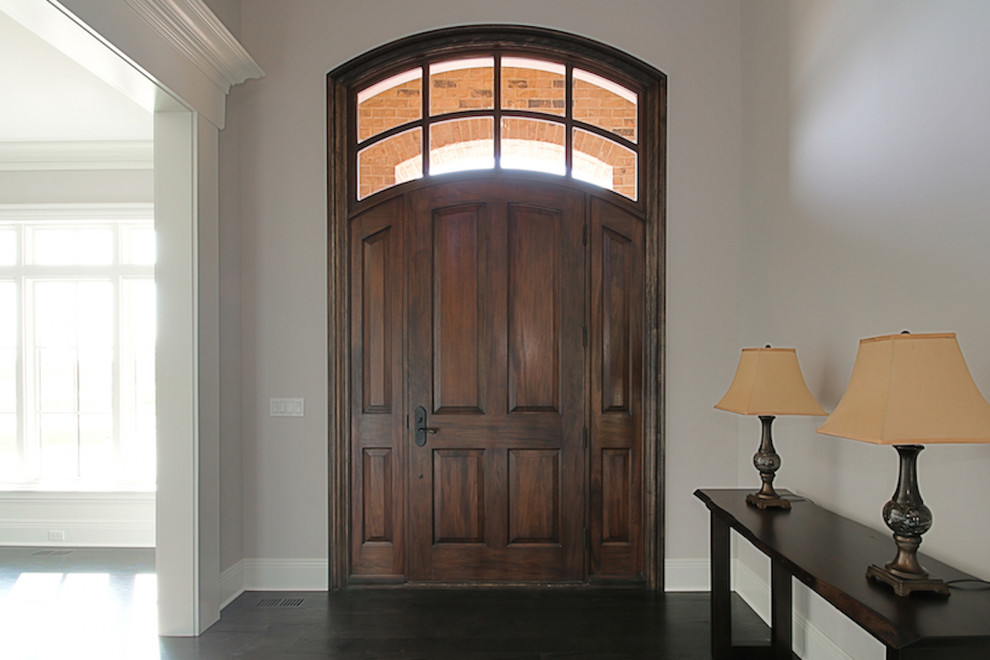 This is an example of a mid-sized transitional front door in Chicago with grey walls, dark hardwood floors, a single front door and a dark wood front door.