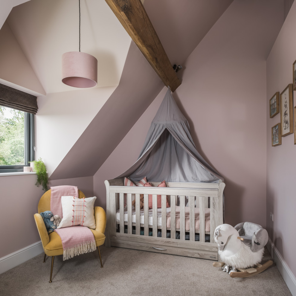 Imagen de habitación de bebé de estilo de casa de campo con paredes rosas, moqueta, suelo gris y vigas vistas