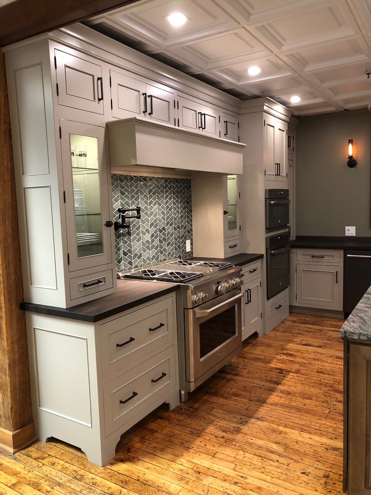 Inspiration for a large arts and crafts l-shaped kitchen pantry in New York with an undermount sink, flat-panel cabinets, grey cabinets, wood benchtops, green splashback, porcelain splashback, stainless steel appliances, medium hardwood floors, with island, brown floor and brown benchtop.
