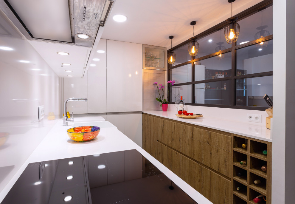 Geschlossene, Zweizeilige Moderne Küche ohne Insel mit Waschbecken, hellbraunen Holzschränken, Küchenrückwand in Weiß, Küchengeräten aus Edelstahl, weißer Arbeitsplatte und eingelassener Decke in Barcelona