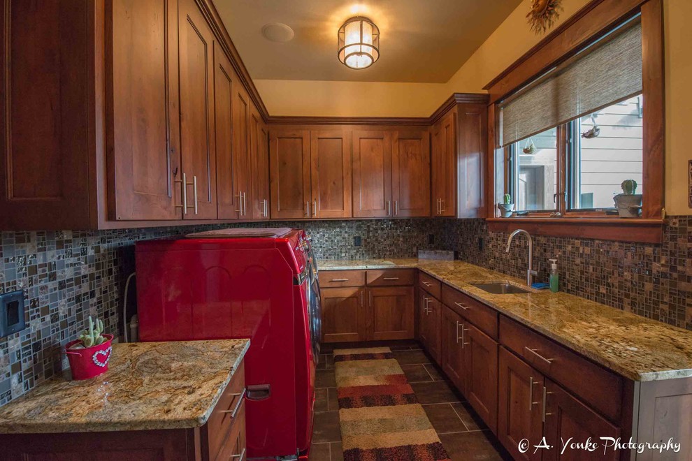 This is an example of a mid-sized country u-shaped dedicated laundry room in Other with an undermount sink, shaker cabinets, dark wood cabinets, granite benchtops, beige walls, slate floors and a side-by-side washer and dryer.