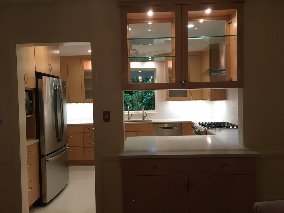 Inspiration for a mid-sized transitional u-shaped porcelain tile and gray floor enclosed kitchen remodel in DC Metro with an undermount sink, flat-panel cabinets, medium tone wood cabinets, quartz countertops, white backsplash, porcelain backsplash, stainless steel appliances and no island