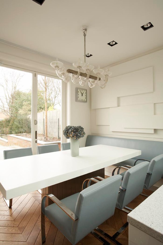 Photo of a contemporary dining room in London with white walls and medium hardwood floors.
