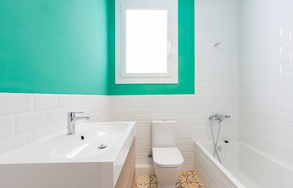 Photo of a small contemporary master bathroom in Barcelona with a drop-in tub, a shower/bathtub combo, a two-piece toilet, ceramic tile, mosaic tile floors, a trough sink and green walls.