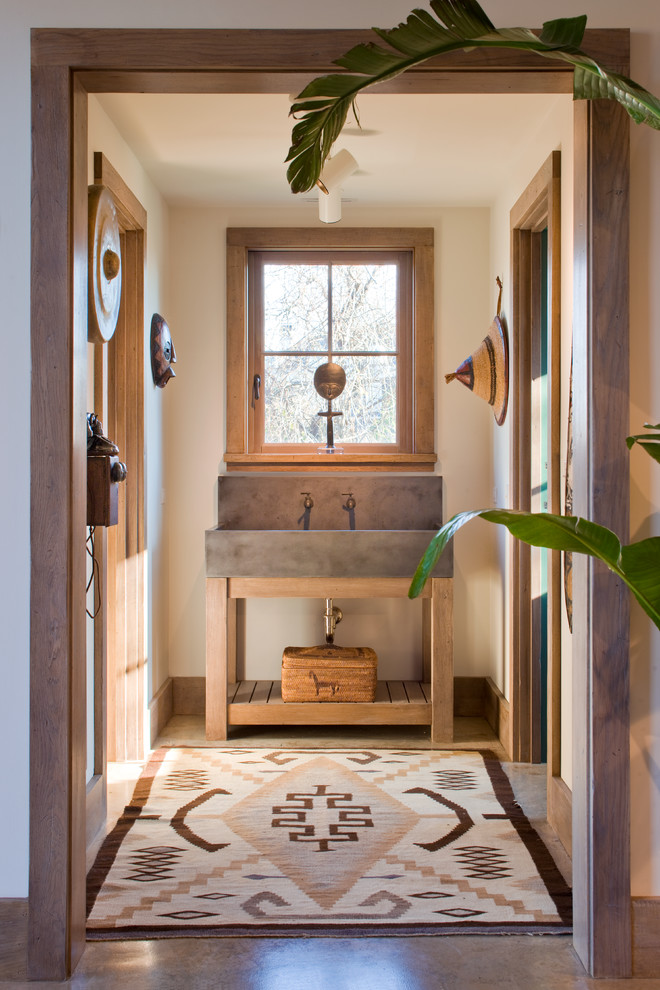 This is an example of a mid-sized master bathroom in Boston with white walls, dark hardwood floors, medium wood cabinets, a trough sink and open cabinets.