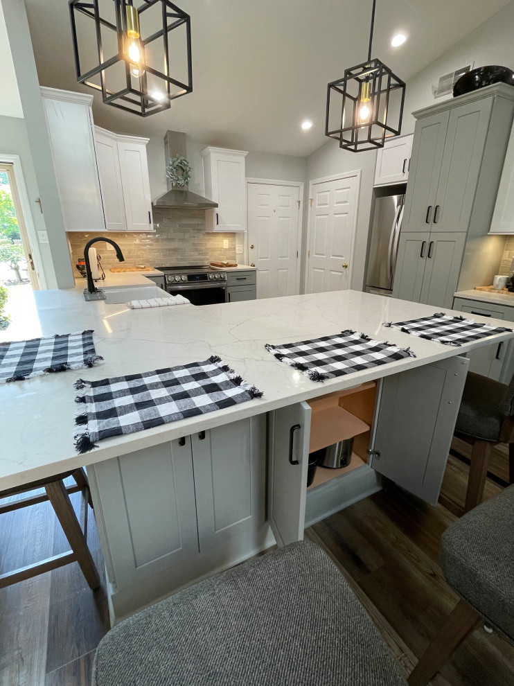 Inspiration for a mid-sized transitional u-shaped vinyl floor and brown floor eat-in kitchen remodel with a farmhouse sink, shaker cabinets, white cabinets, quartz countertops, gray backsplash, subway tile backsplash, stainless steel appliances, no island and white countertops