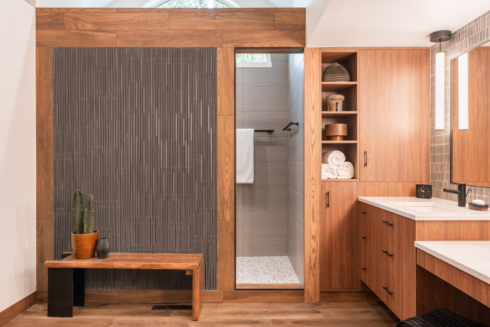 Inspiration for a large contemporary master gray tile and porcelain tile laminate floor, brown floor, double-sink, vaulted ceiling and wallpaper open shower remodel in Minneapolis with flat-panel cabinets, medium tone wood cabinets, a one-piece toilet, white walls, an undermount sink, quartzite countertops, white countertops and a floating vanity