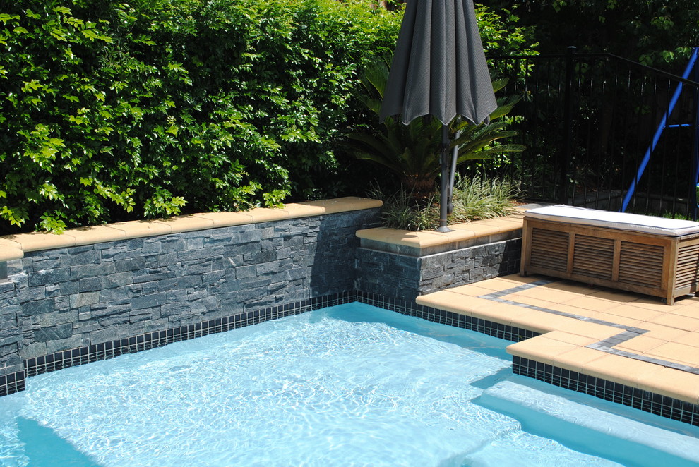 This is an example of a small contemporary backyard rectangular lap pool in Sydney with a water feature and tile.