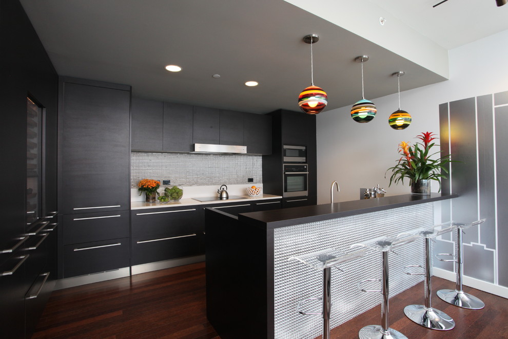 Photo of a contemporary galley kitchen in Los Angeles with flat-panel cabinets, black cabinets, metallic splashback, panelled appliances and metal splashback.