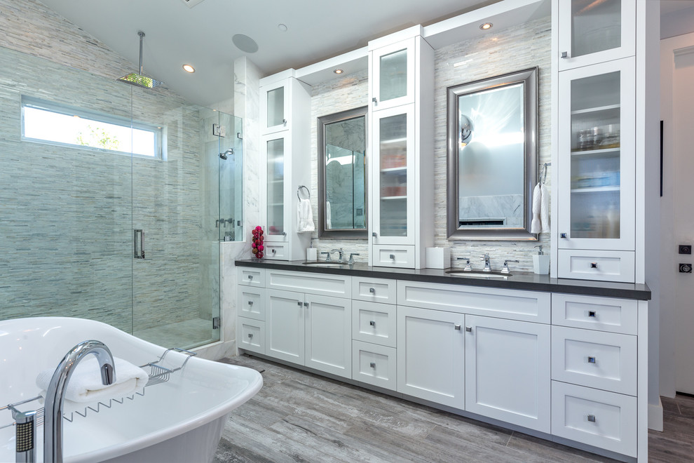 Beach style master bathroom in Los Angeles with shaker cabinets, white cabinets, a freestanding tub, gray tile, grey walls, an undermount sink, quartzite benchtops, grey floor and a hinged shower door.