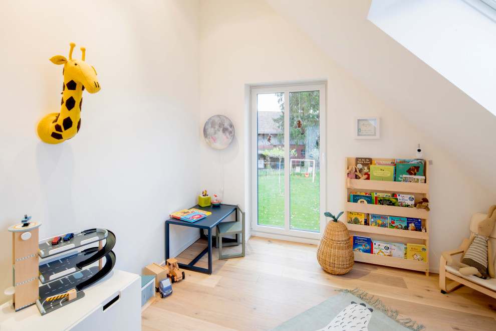 Design ideas for a mid-sized contemporary kids' playroom for kids 4-10 years old and boys in Dusseldorf with white walls, light hardwood floors and beige floor.