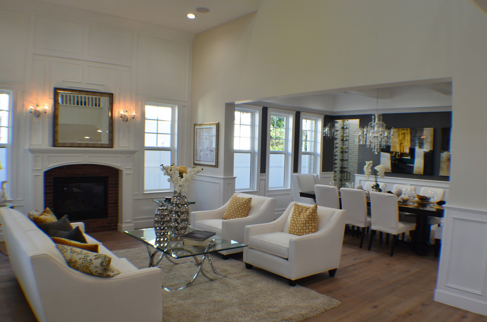 Inspiration for a mid-sized transitional formal open concept living room in Los Angeles with beige walls, light hardwood floors, a standard fireplace, a brick fireplace surround, brown floor and no tv.