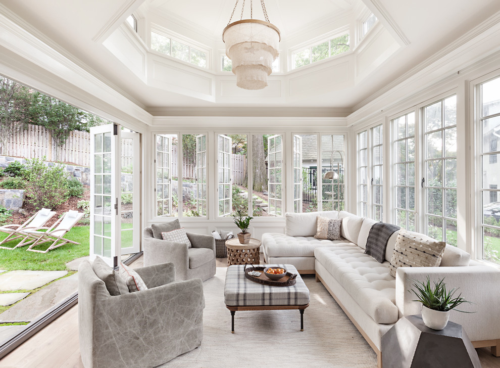 This is an example of a large traditional sunroom in New York with light hardwood floors, no fireplace, a standard ceiling and brown floor.