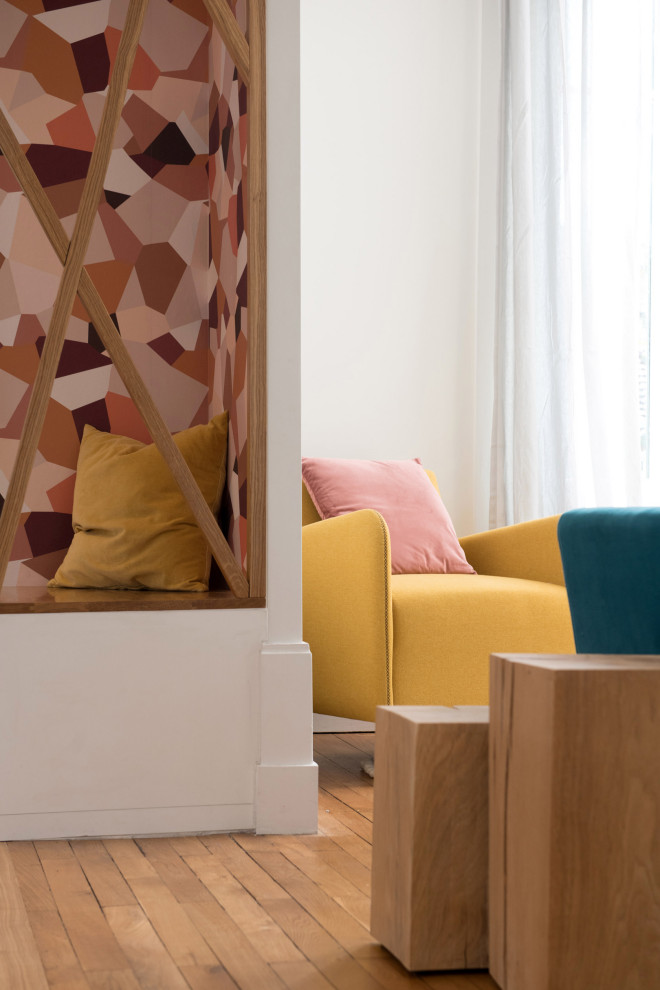 На фото: большая открытая гостиная комната в современном стиле с с книжными шкафами и полками, розовыми стенами, бетонным полом, двусторонним камином, фасадом камина из камня и разноцветным полом