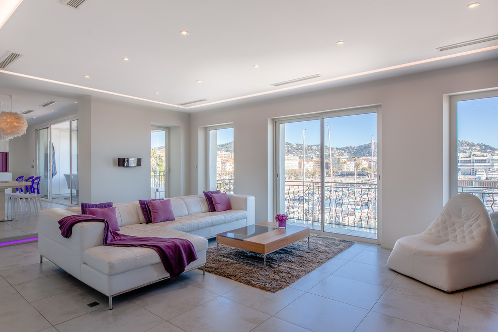 This is an example of a contemporary open concept living room in Nice with white walls and beige floor.