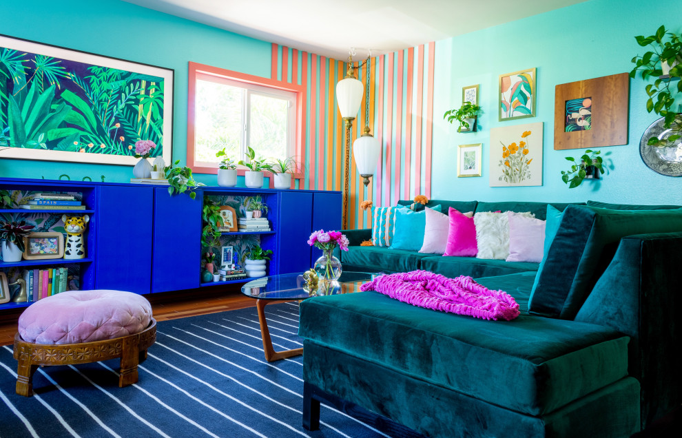 Inspiration pour un salon ethnique de taille moyenne et fermé avec un mur bleu, un sol en bois brun, un téléviseur fixé au mur, du lambris et un sol rouge.