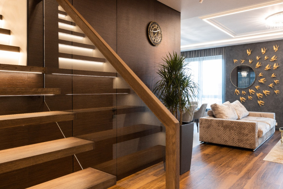 Стильный дизайн: прямая деревянная лестница среднего размера в современном стиле с деревянными ступенями и стеклянными перилами - последний тренд