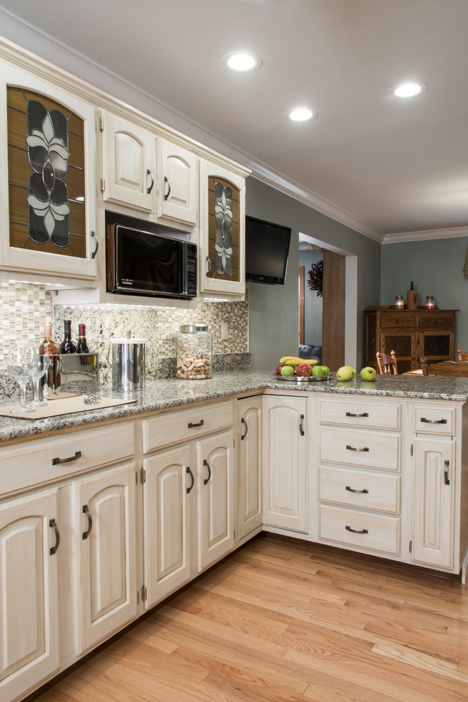 Kitchen pantry - transitional medium tone wood floor kitchen pantry idea in St Louis with a drop-in sink, distressed cabinets, granite countertops, multicolored backsplash and glass tile backsplash