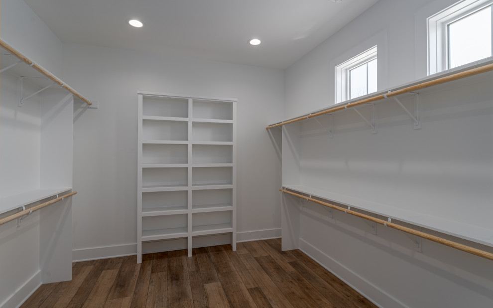 This is an example of a large country gender-neutral walk-in wardrobe in Atlanta with vinyl floors and brown floor.