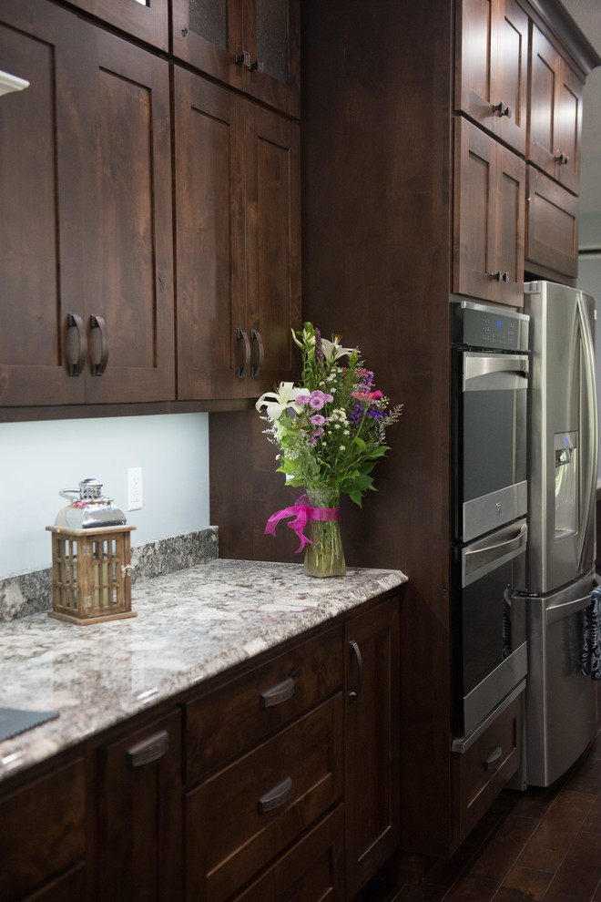 Open concept kitchen - transitional l-shaped open concept kitchen idea with an undermount sink, shaker cabinets, dark wood cabinets, granite countertops, stainless steel appliances, an island and multicolored countertops
