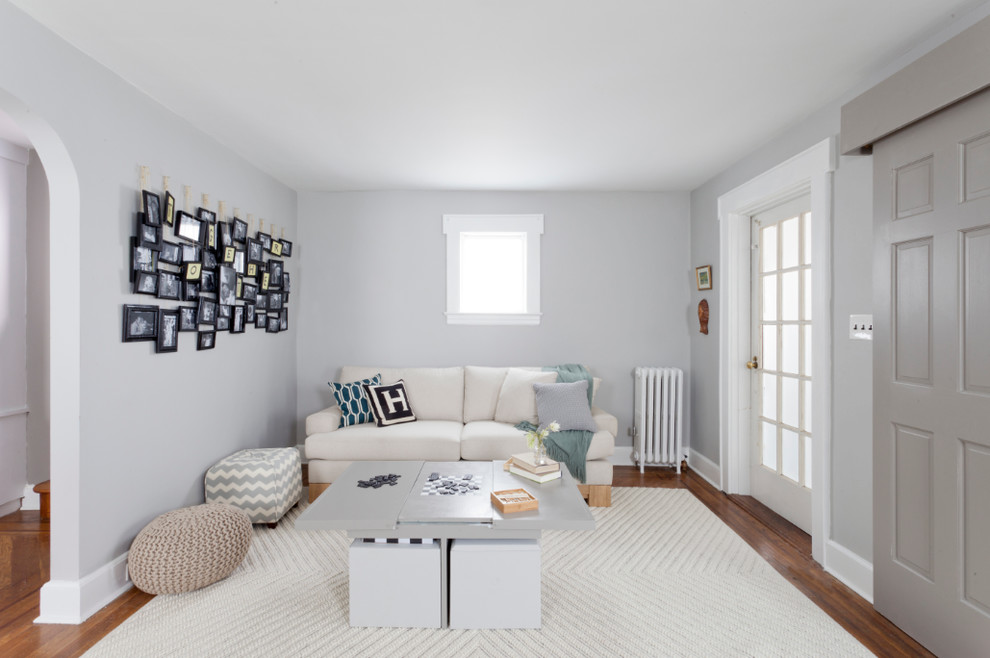 Example of a transitional living room design in New York with gray walls
