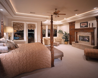 Inspiration for an expansive traditional master bedroom in Las Vegas with beige walls, carpet, a standard fireplace, a stone fireplace surround and beige floor.