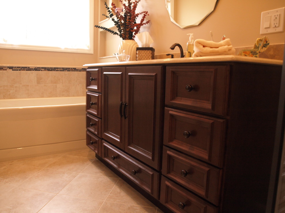 Inspiration for a small traditional master bathroom in Newark with beaded inset cabinets, dark wood cabinets, a drop-in tub, a corner shower, a two-piece toilet, beige tile, mosaic tile, beige walls, ceramic floors, an undermount sink, a hinged shower door and beige benchtops.
