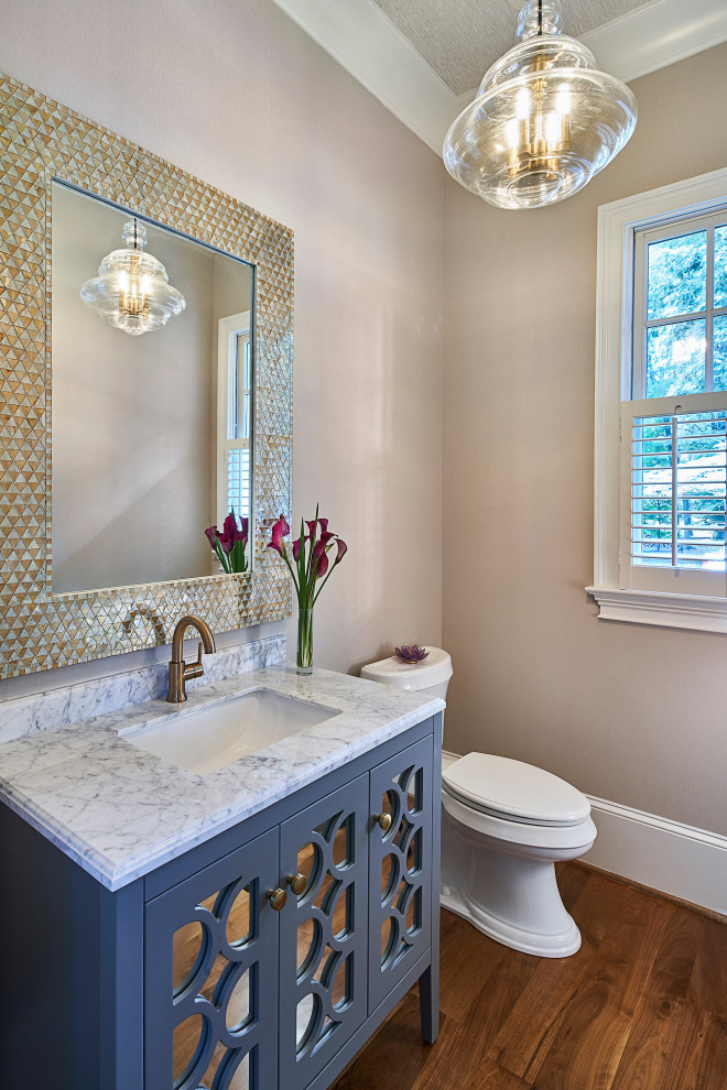 Design ideas for a small transitional powder room in Charlotte with furniture-like cabinets, grey cabinets, a two-piece toilet, beige walls, dark hardwood floors, an undermount sink, marble benchtops, brown floor and grey benchtops.