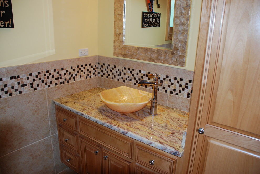 This is an example of a traditional bathroom in New Orleans with granite benchtops and porcelain tile.