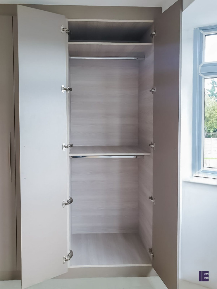 Ejemplo de armario minimalista grande con armarios con paneles lisos y puertas de armario grises