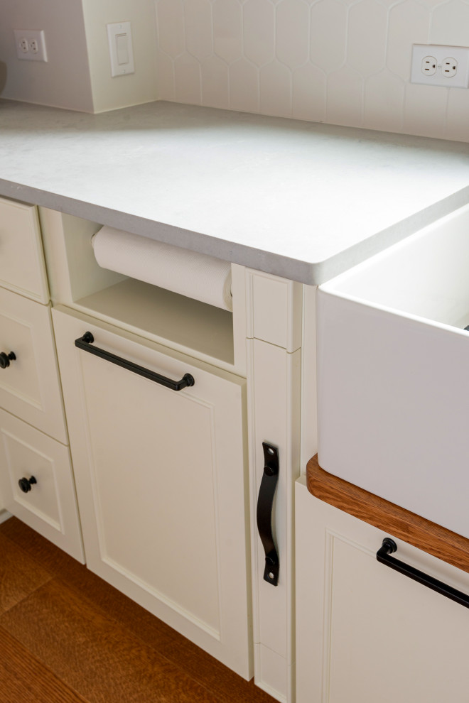 Eat-in kitchen - large medium tone wood floor and exposed beam eat-in kitchen idea with white backsplash, stainless steel appliances and an island