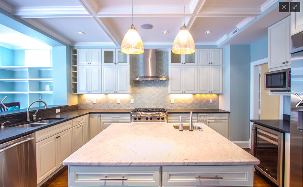 Example of a mid-sized transitional u-shaped medium tone wood floor enclosed kitchen design in Richmond with a double-bowl sink, raised-panel cabinets, white cabinets, granite countertops, blue backsplash, porcelain backsplash, stainless steel appliances and an island