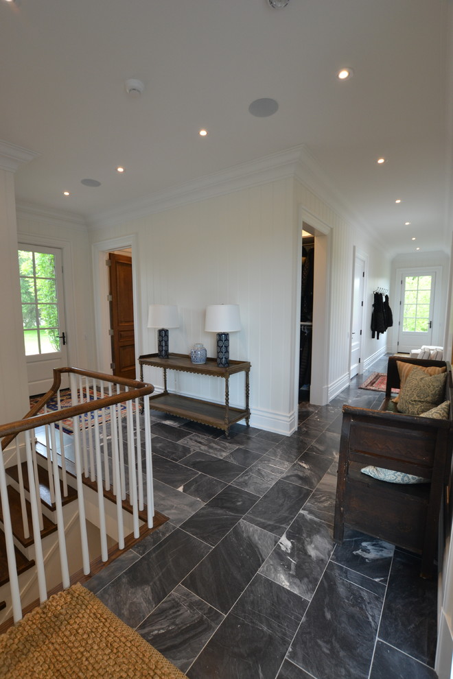 Inspiration for a mid-sized traditional hallway in Toronto with white walls, marble floors and black floor.